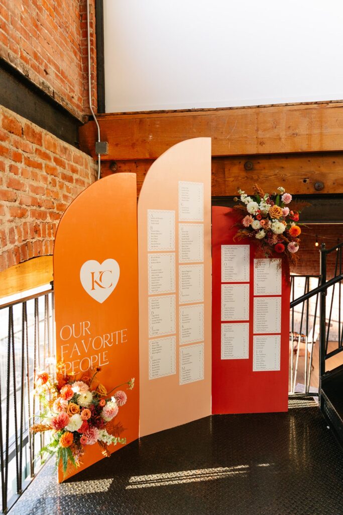 Unique and colorful wedding seating chart display at the entrance of a wedding event at UNION in Kansas City, MO, with floral accents.