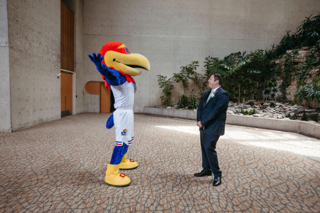 A groom on his wedding day laughing when he sees his college mascot instead of his bride.