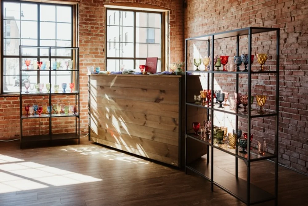 Bar setup at UNION with shelves of colorful vintage glassware for office holiday party.