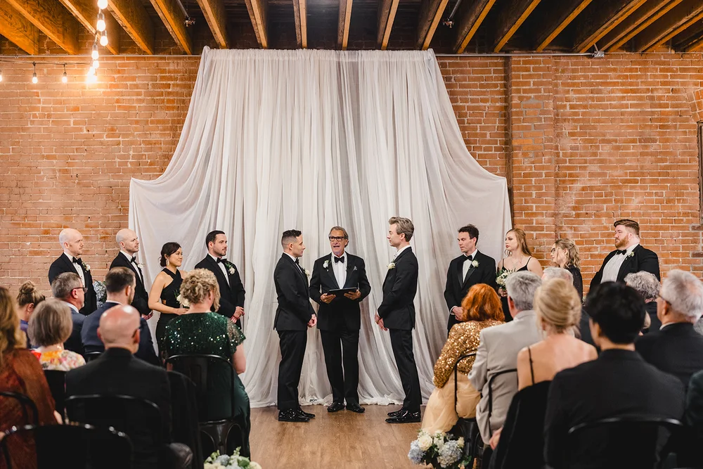 Two grooms saying their vows during a wedding ceremony at UNION Kansas City